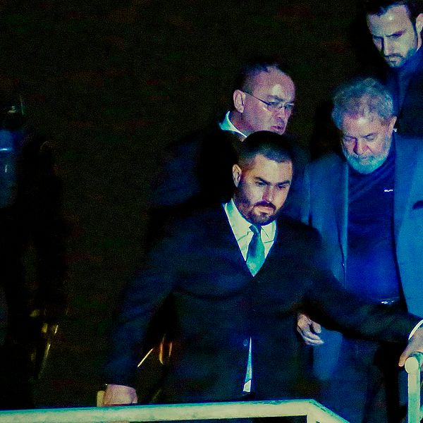 Lula da Silva överlämnade sig själv och anlände till polisen (iförd grå kostym) under lördagen.