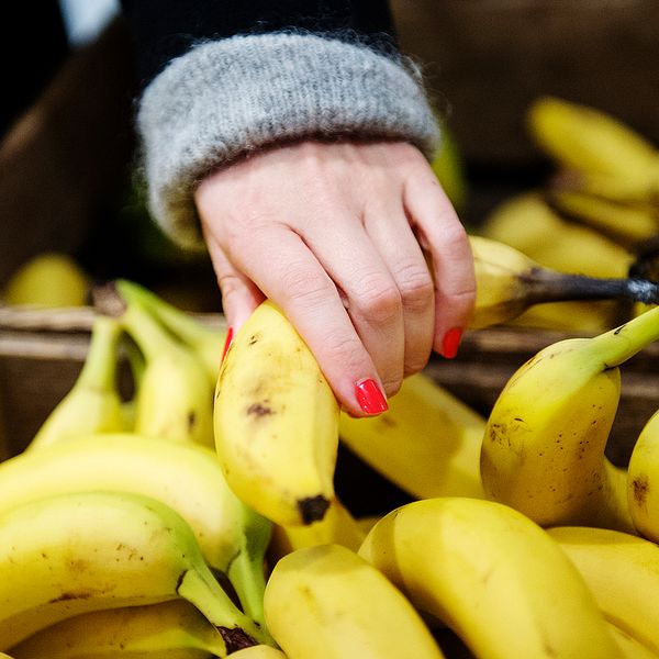 En hand som tar i en banan.