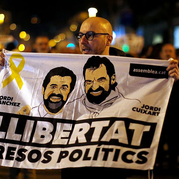 En demonstrant håller upp en bild på Jordi Sanchez och Jordi Cuixart, till stöd för de två fängslade katalanska ledarna.