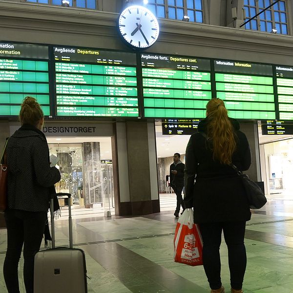 Personer som väntar på en tågstation.