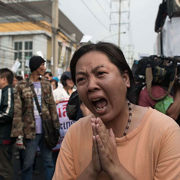 En kvinna skriker ut sin frustration efter skottlossningen i Bangkok.