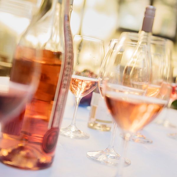 Två flaskor rosévin och halvfulla glas framdukade på ett vit bord