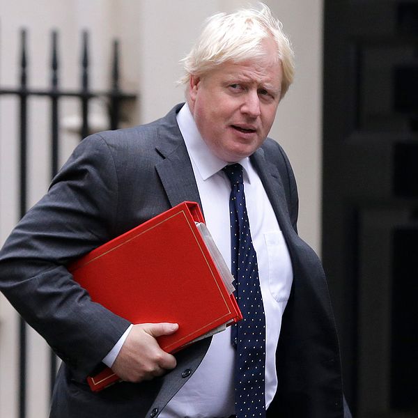 Storbritanniens utrikesminister Boris Johnson gåendes med en röd pärm under armen.