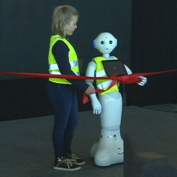 Flicka med skyddsväst och robot.