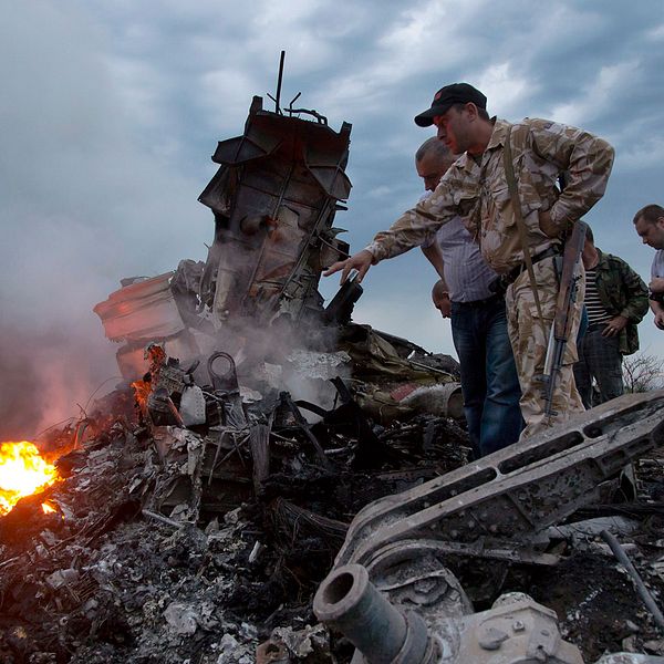 Människor undersöker vraket från planet MH17 i Ukraina i juli 2014.