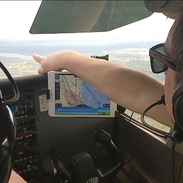 Pilot pekar ut genom flygplansfönster