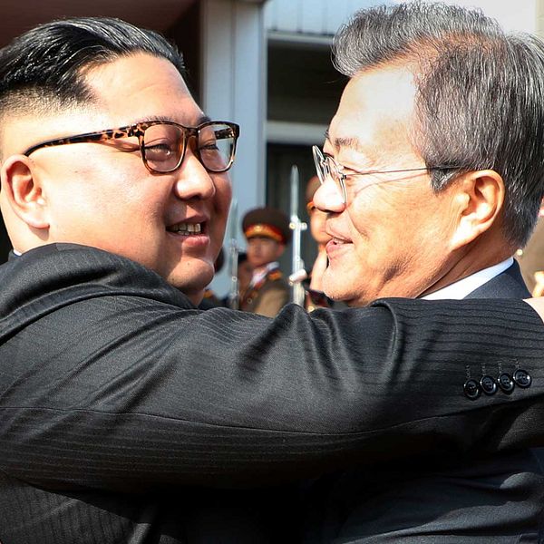 Nordkoreas ledare Kim Jong Un och Sydkoreas president Moon Jae-In kramar varandra inför en samling fotografer.