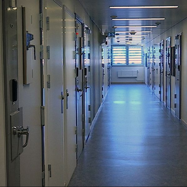 Korridor på säkerhetsanstalten Saltvik. Stängda dörrar på besöksavdelningen och ett fönster med galler i slutet av korridoren.