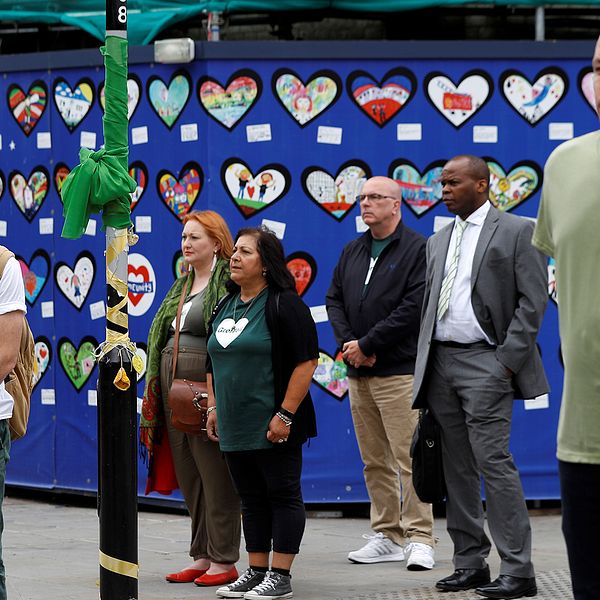 Människor i London står tysta och hedrar alla människor som omkom under branden i Grenfell tower den 14 juni 2017.