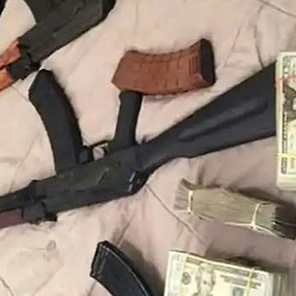 En bild från polisens förundersökning på pengar och skjutvapen på vad som ser ut att vara ett sängöverkast.