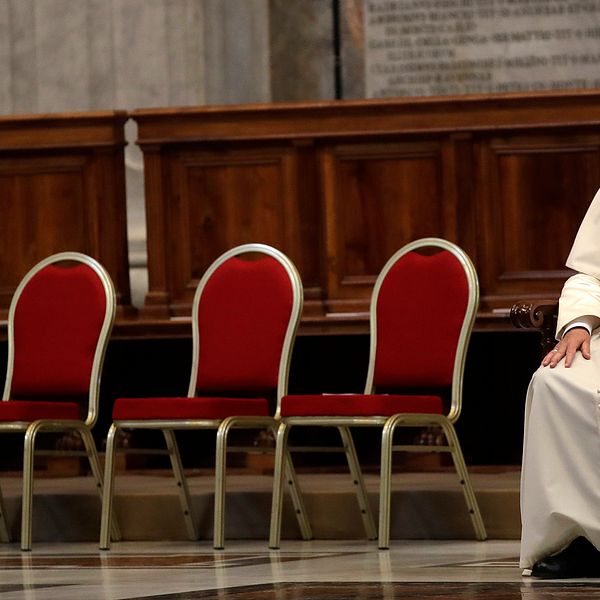 Påven Franciskus sitter ner med fyra tomma stolar bredvid sig.