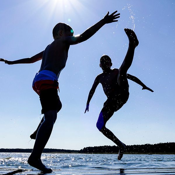 Två pojkar leker på en brygga i sommarvärmen.