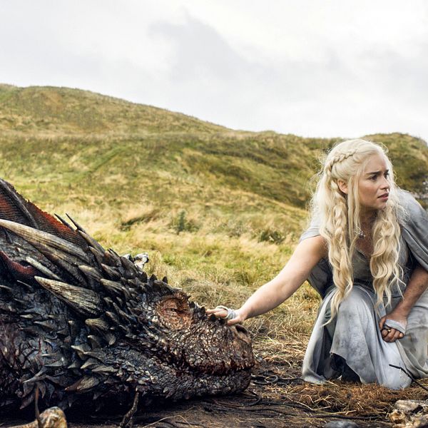 En bild från serien Game of Thrones där en av huvudpersonerna klappar en drake.