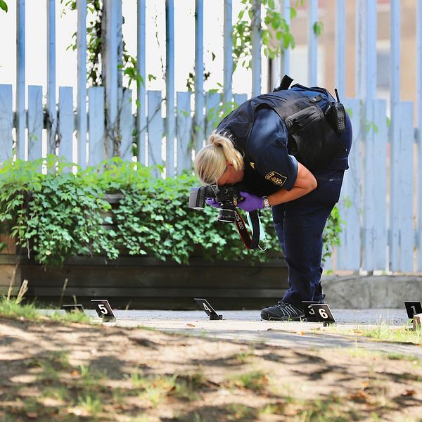 En polis som undersöker platsen där mannen sköts av polisen.