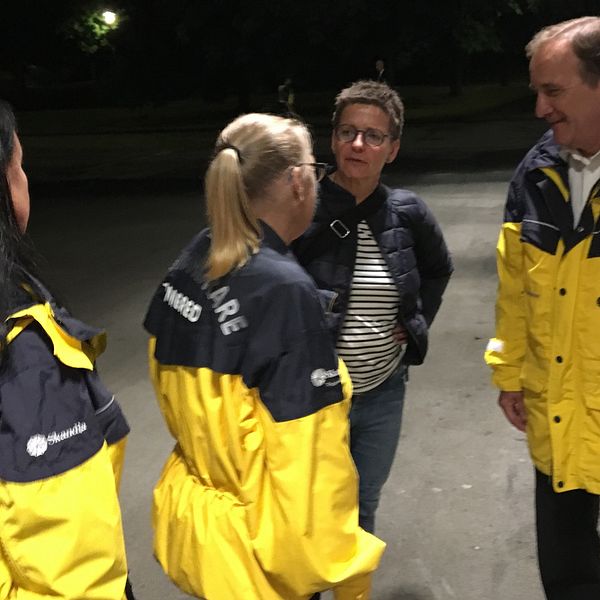 Löfven och Hermansson tillsammans med nattvandrare i gula jackor.