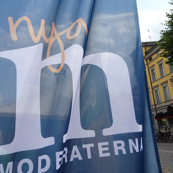 Moderaternas logotype på flagga på Stortorget i Örebro. Engelbrektsstatyn syns igenom.