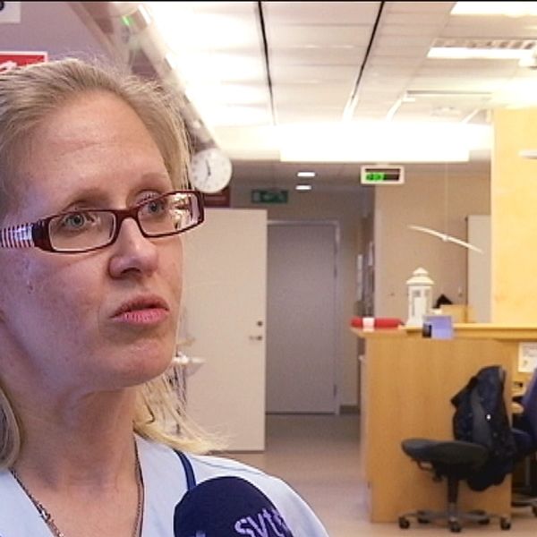 Porträttbild på sjuksköterskan Annki Svedberg som står i en sjukhuskorridor.