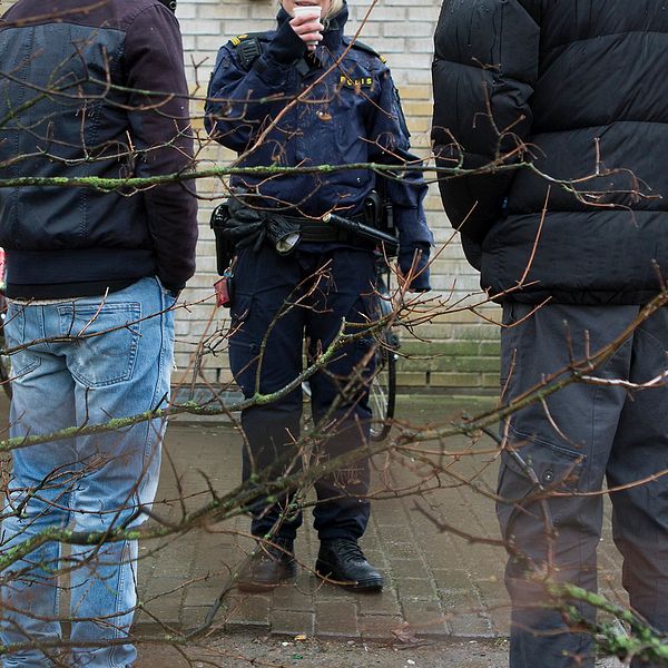 Elever på en skolgård som pratar med en polis.