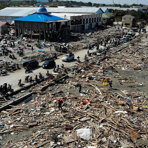 Överlevande söker efter användbara föremål i ruinerna i Palu, Indonesien.