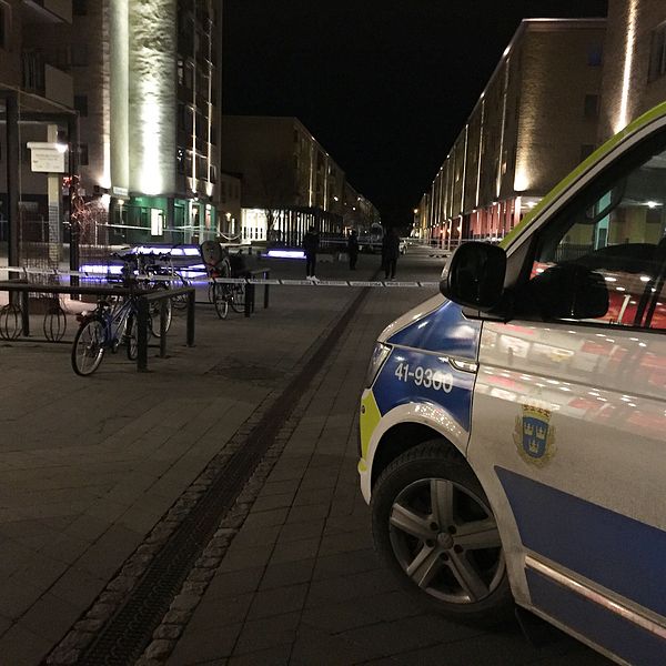 Polisbil och avspärrningsband på nattlig gata.
