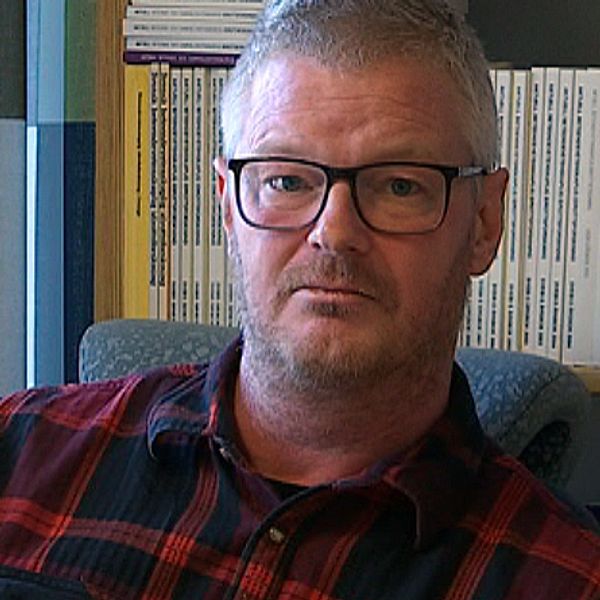 Idrottsforskaren Josef Fahlén sitter på ett kontor i Umeå med en bokhylla i bakgrunden.