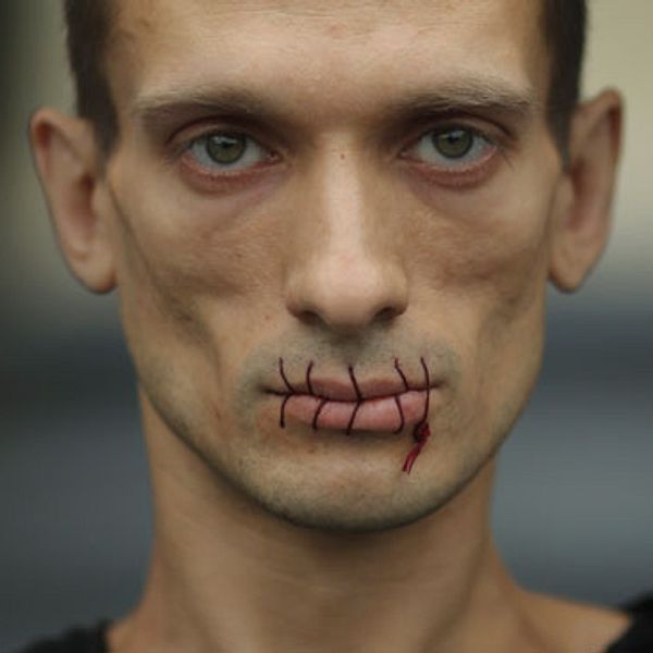 Ryska performanceartisten Petr Pavlensky har sytt ihop sina läppar i protest mot att de Putin-kritiska aktivisterna i Pussy Riot fortfarande sitter i häktet.