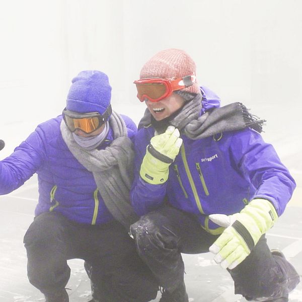 SVT:s meteorolog Nils Holmqvist och reporter Torbjörn Averås Skorup i klimattunneln där det blåser stark vind och snöar.