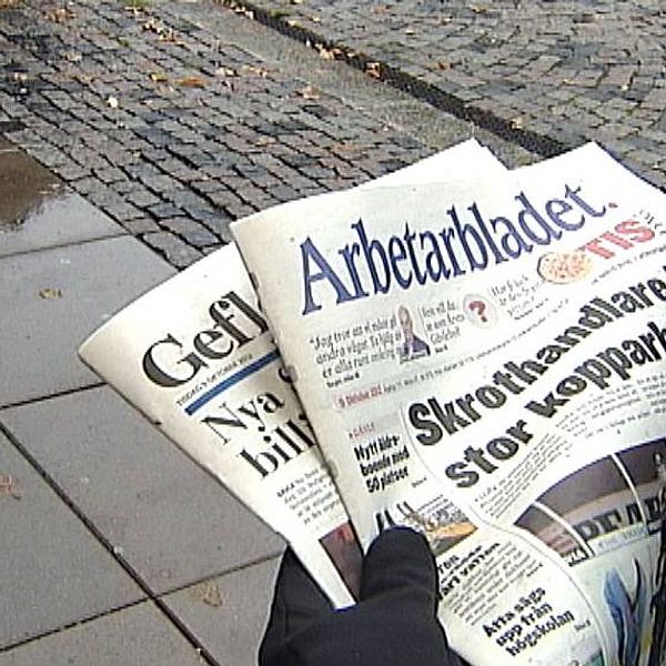 någon håller två tidningar ute på gatan: Gefle dagblad och Arbetarbladet