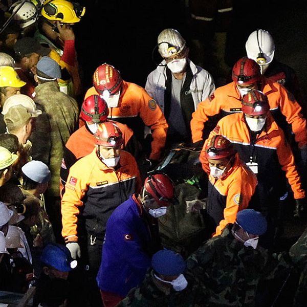 Räddningsarbetare bär ut en död från gruvan i Soma.