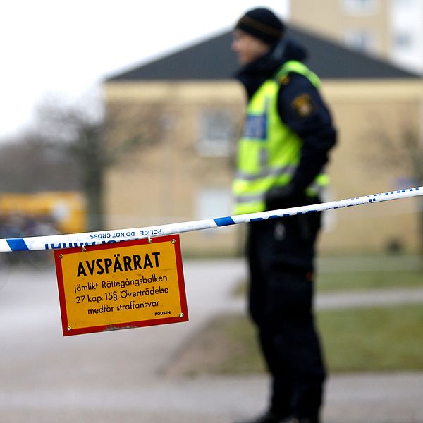 En polis vid en plats där en man sköts till döds av polis