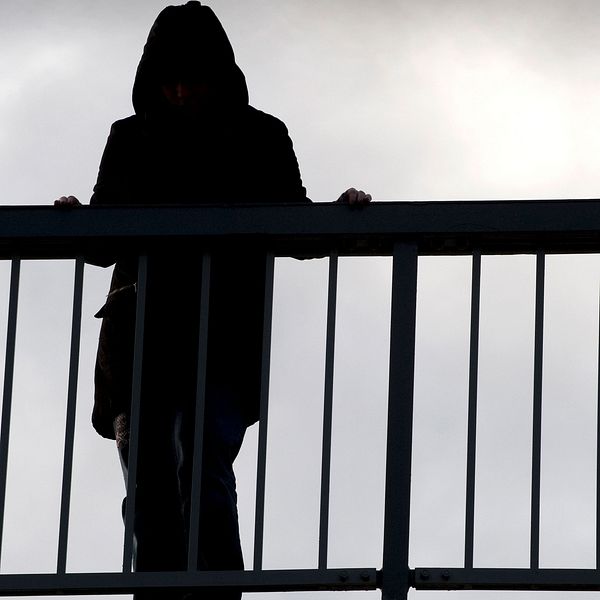 En kvinna står på en bro.