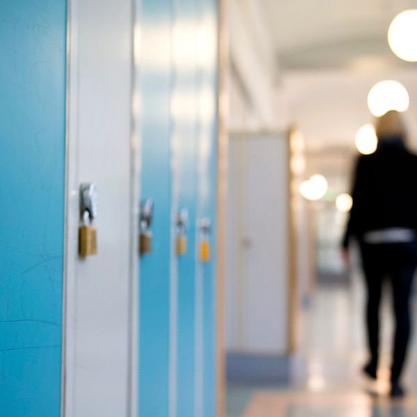 En elev går i en skolkorridor.
