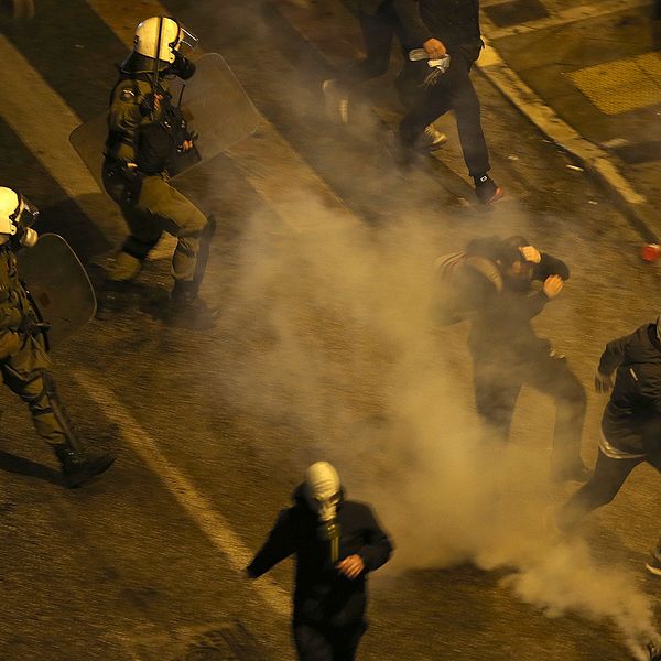 Grekisk polis kastas tårgas mot demonstranter utanför parlamentet i Aten.