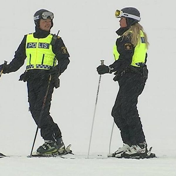 två poliser på slalomskidor i snöväder