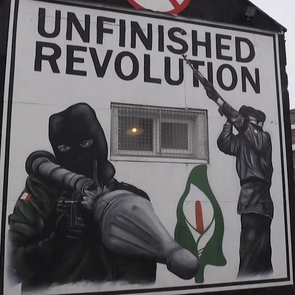 Väggmålning med maskerade men med raketgevär och texten unfinished revolution