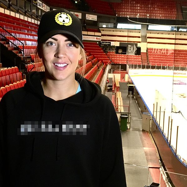 porträtt på en tjej som står på läktaren i hockey-arena
