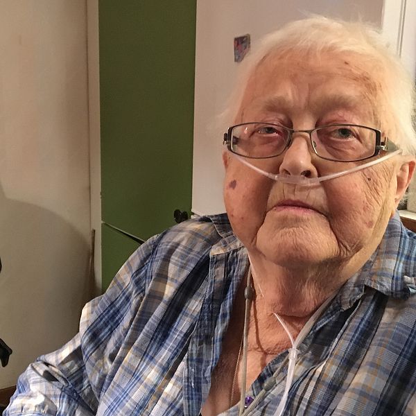 Äldre kvinna, Margon Landgren i Rossön, sitter med syrgas vid sitt köksbord
