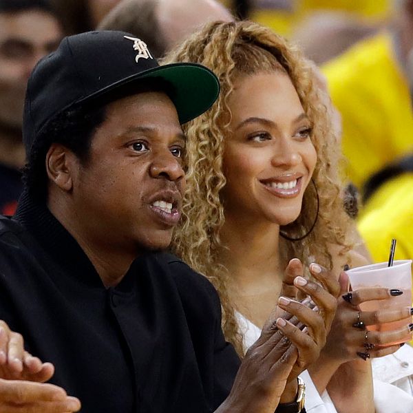 Beyoncé och Jay-z sitter ner och klappar i händerna.