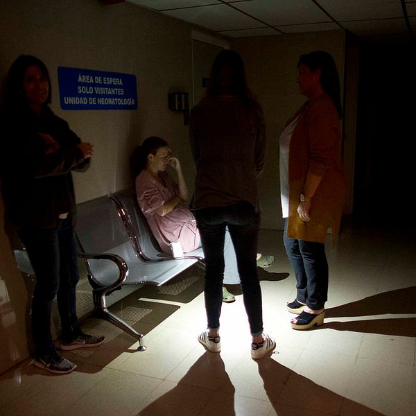 Anhöriga väntar i en strömlös korridor vid en intensivvårdsavdelning för spädbarn i Caracas under strömavbrottet.