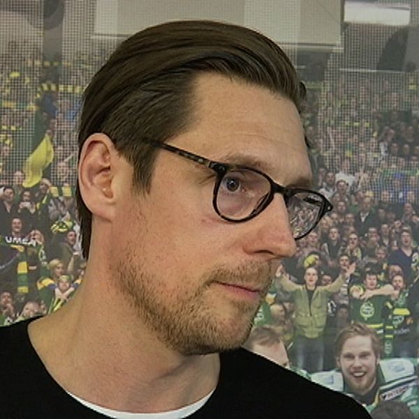 en man med brunt hår och rundade svartmelerade glasögon
