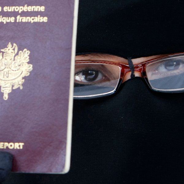En fransk kvinna håller upp sitt pass under en presskonferens 2010, när lagen trädde i kraft.