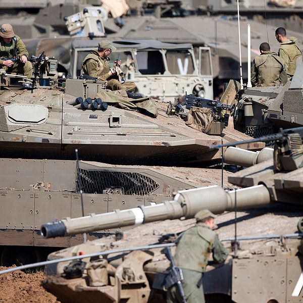 Israeliska soldater arbetar med sina pansarvagnar i ett samlingsområde i närheten av Gazaremsan. Israeliska pansarstyrkor har placerats ut längs gränsen under det senaste dygnet.