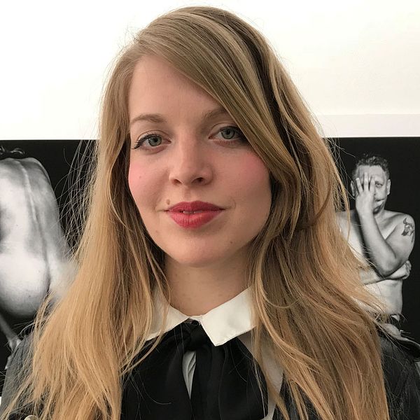 lUrika Mohlavyr Mohlin står framför två av sina fotografier