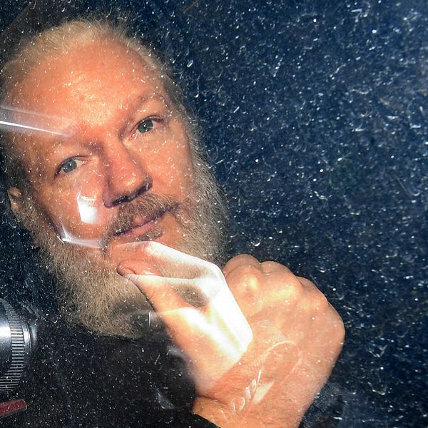 Julian Assange gestikulerade när han anlände till domstolen Westminster Magistrates' Court i London.