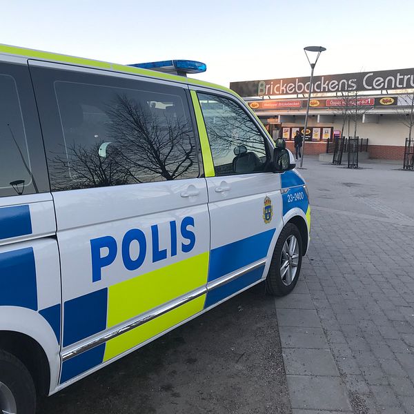 En polisbil står parkerad i Birckebackens centrum.