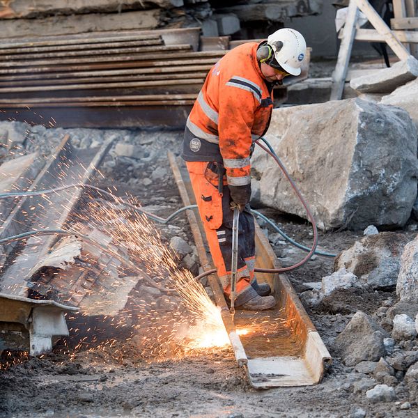 En byggarbetare med skärbrännare arbetar vid ombyggnaden av Slussen i Stockholm.