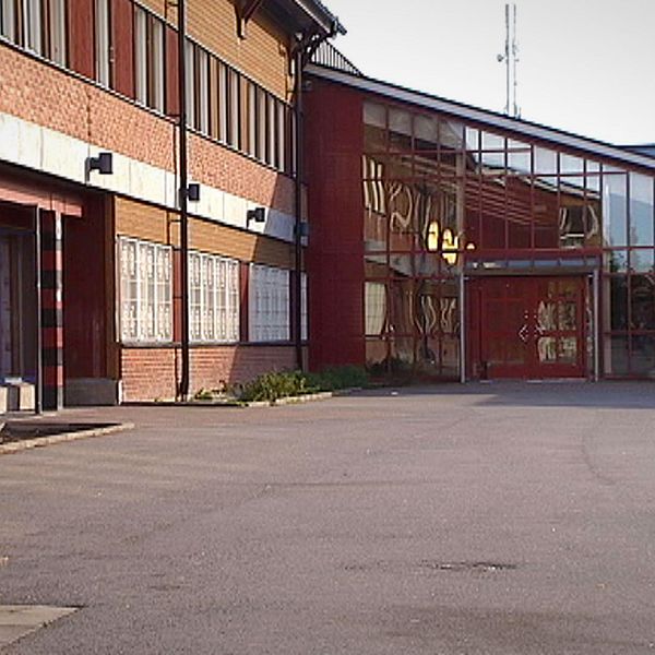 Exteriör bild på Vivallaskolan med asfaltsplan framför.