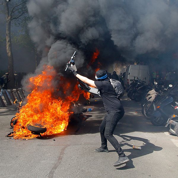 En demonstrant vid ett moln av röd och eld.