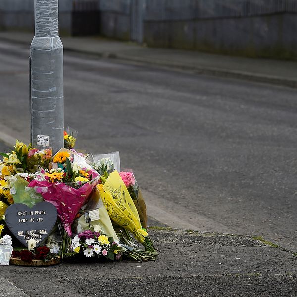 Blommor på asfalterad gata vid en lyktstolpe.