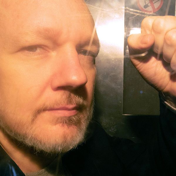 Julian Assange fotograferad genom rutan på fångtransporten utanför domstolen i London, dit han anlände 1 maj för att delges fängelsedomen för borgensbrott